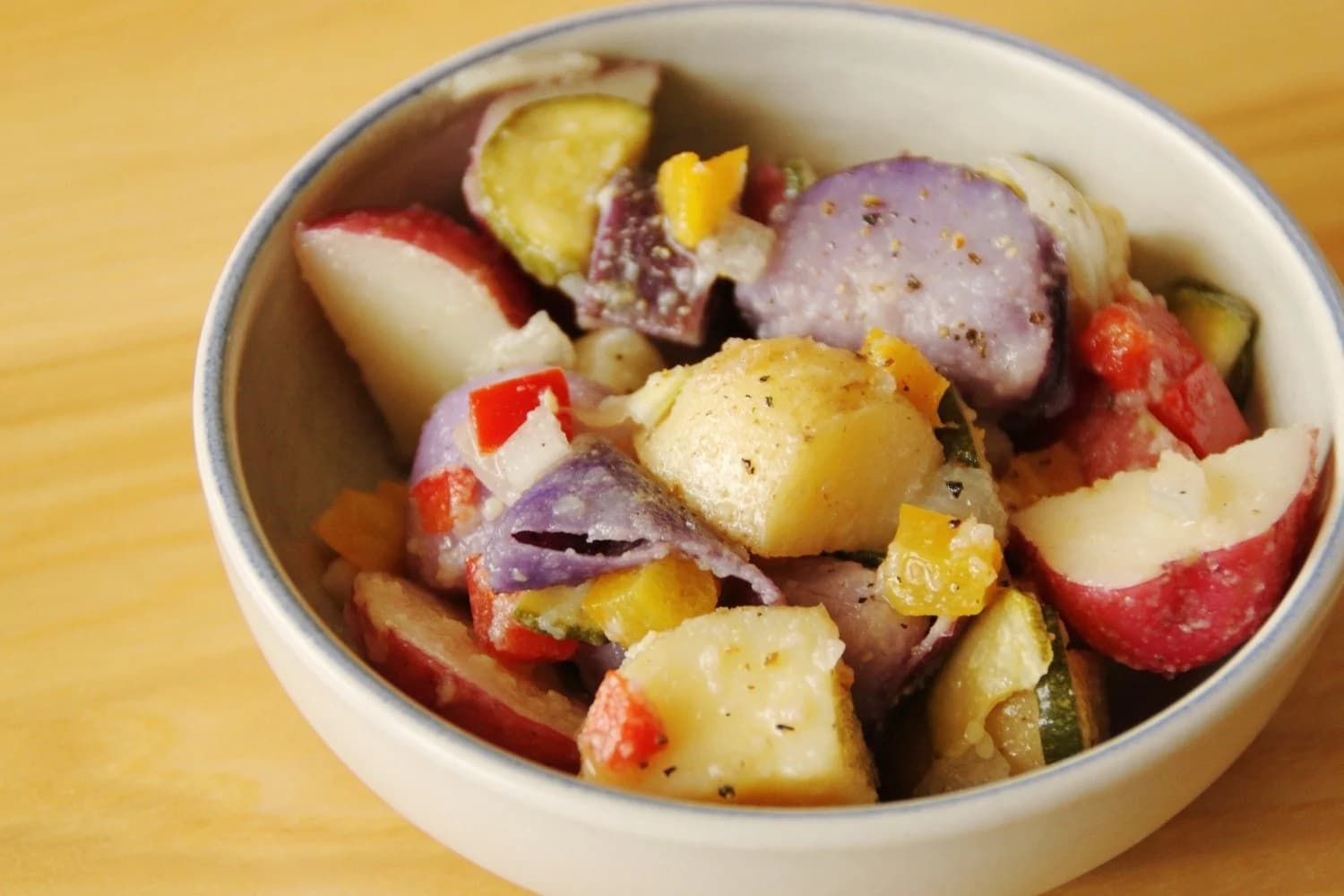 A bowl of potato salad made with different colored potatoes